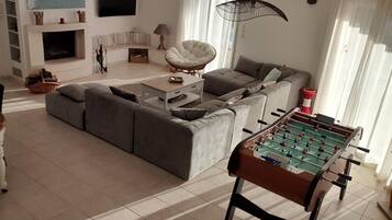 Télévision, cheminée, baby-foot, livres