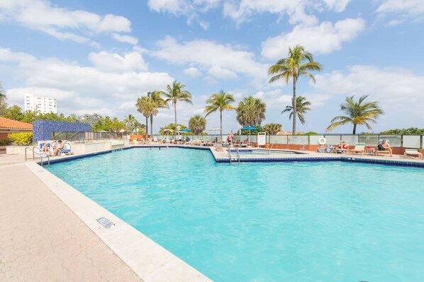 A swimming pool with lounge chairs and palm trees. - 607 Apartment Hollywood Beach (Hollywood)