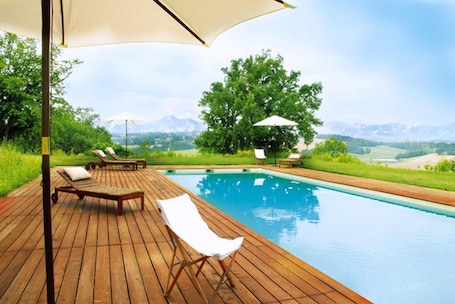 Seasonal outdoor pool, a natural pool, pool umbrellas, pool loungers. La Maison de Bazugues