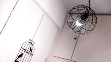 Una habitación con una lámpara colgante y una jaula decorativa.
