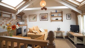 A cozy loft apartment with a kitchen, living area, and a balcony. - Abbey Place Net Loft (Penzance)