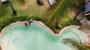 Una piscina al aire libre, sillones reclinables de piscina