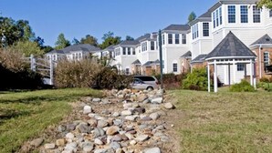 A row of white houses with a stone pathway leading to a gazebo. - Great for Large Family/Group. Suitable for 12. Popular Resort near Attractions. (Williamsburg)