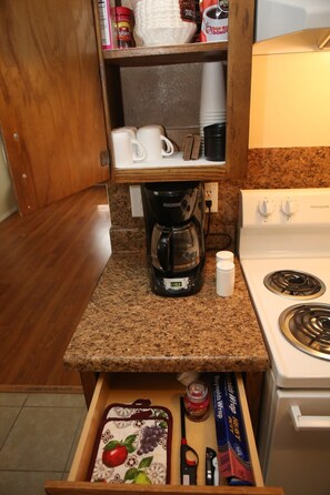 A kitchenette with a coffee maker, a stove, and a drawer with kitchen utensils. - Spacious 2BR/1BA Stay Minutes from Fort Sill (Lawton)