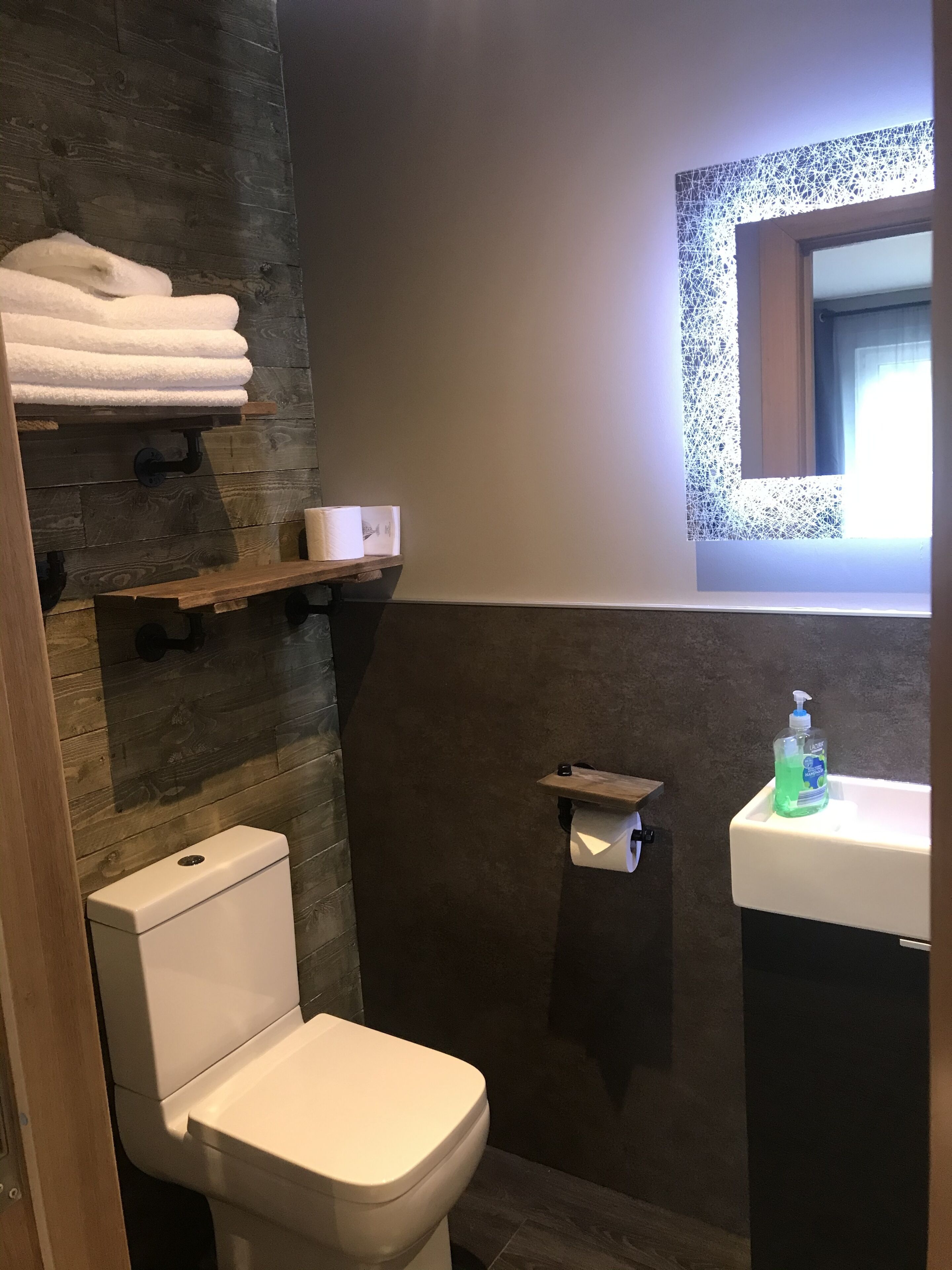 A modern bathroom with a toilet, a sink, and a shower area.