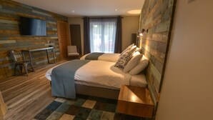 Une chambre d’hôtel moderne dotée d’un grand lit, d’un téléviseur fixé au mur, d’un bureau et offrant une vue sur l’extérieur par une fenêtre.