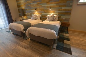 A hotel room with two beds, wooden flooring, a modern wall design, and a view of the outdoors. - The Shack and Pods at Inchree (Fort William)