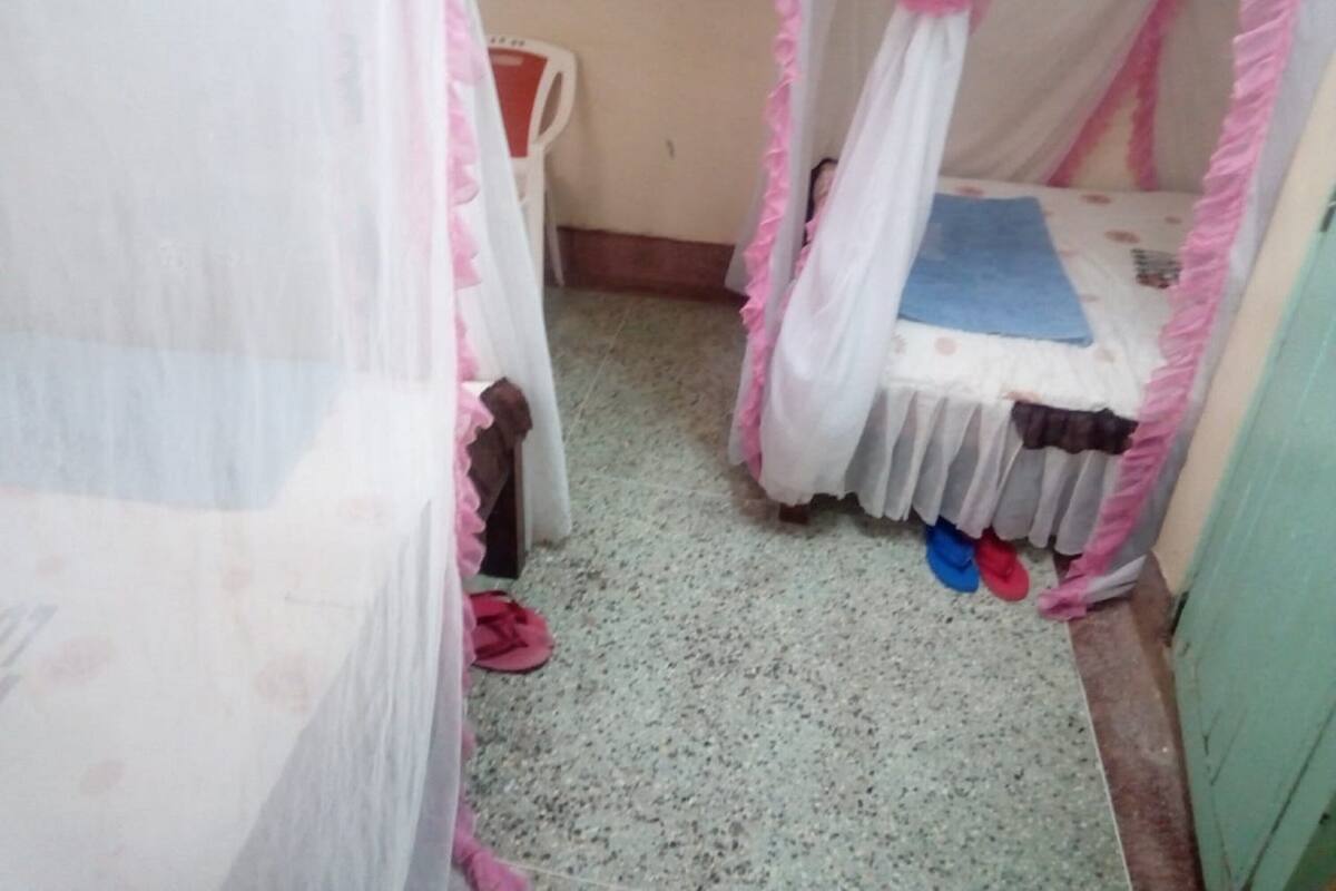 A small, enclosed room with a cot and a mosquito net.