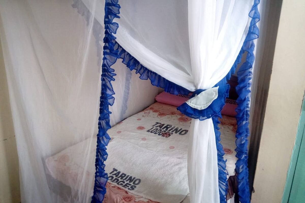 A small, enclosed sleeping area with a canopy and a bed with a floral bedspread.