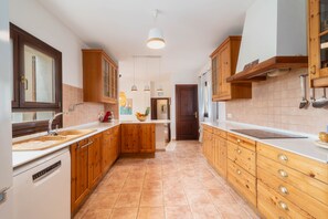 A kitchen with wooden cabinets, a white countertop, and a built-in oven.