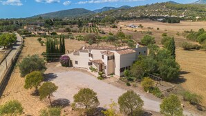 Il s’agit d’une propriété résidentielle dotée d’une allée spacieuse, d’un grand jardin et offrant une vue sur la campagne environnante.
