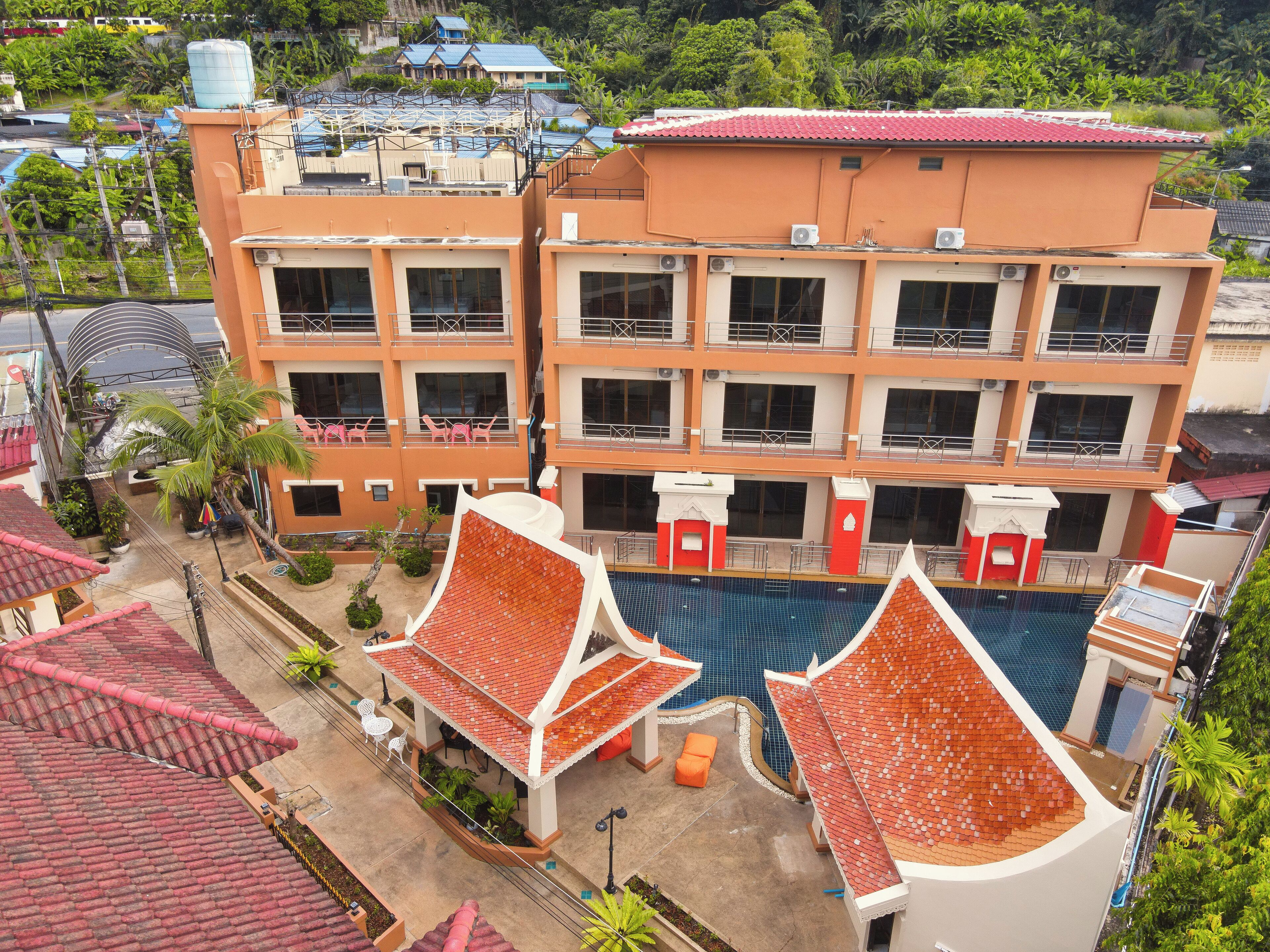 A multi-story hotel with a swimming pool and outdoor seating areas.