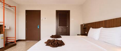 A hotel room with a bed, a wardrobe, a mirror, and a small table.
