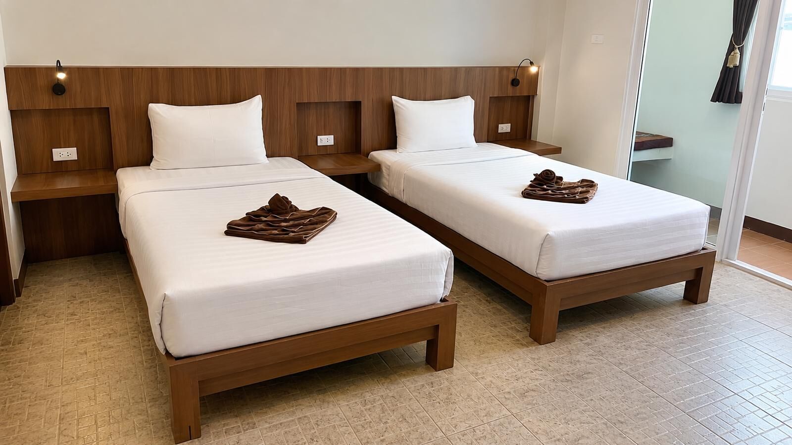 Habitación de hotel con dos camas, cabeceros de madera, ropa de cama blanca y piso de baldosas.
