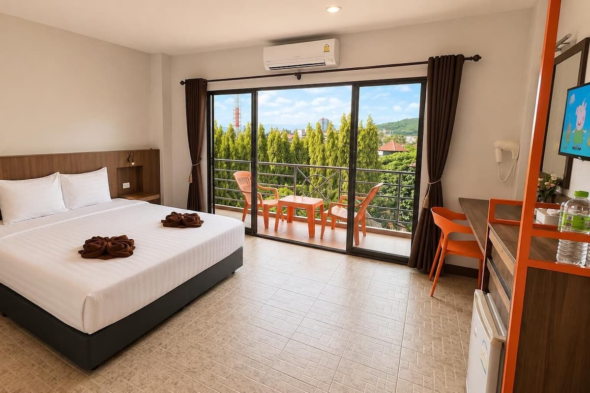 A hotel room with a bed, a desk, a chair, and a balcony with a view.