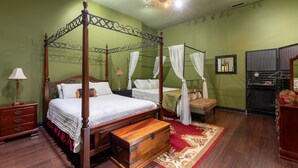 A four-poster bed with a wooden headboard, a bedside table with a lamp, and a bench. - Easy access to Taylor Swift, Broadway, CMAs & more (Nashville)