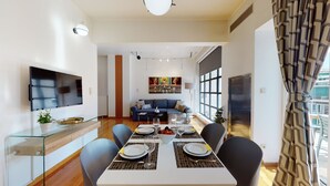 Ein modernes Wohnzimmer mit Sofa, Fernseher und Kunstwerken an der Wand.