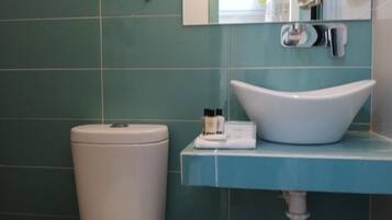 Ein Badezimmer mit Toilette, Waschbecken und einem Spiegel darüber.