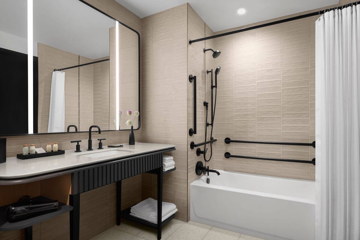 A modern bathroom with a bathtub, a sink, and a shower area.