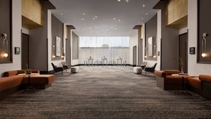 En rymlig hotellobby med mattbeklädd golv, sittgrupper och ett stort fönster som erbjuder en fin utsikt.