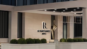 Renaissance-hotellets fasad utmärks av en tydlig logotyp i form av bokstaven ”R”, modern arkitektur och välskött trädgårdsanläggning.