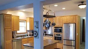 A modern kitchen with wooden cabinets, stainless steel appliances, and a granite countertop. - River Life at it's Best (Chillicothe)