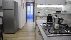 A modern kitchen with a stainless steel stove, a refrigerator, and a toaster.