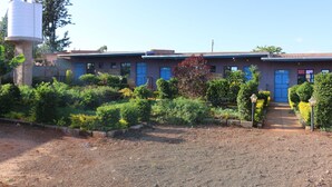A building with a blue door and a water tank to the left.