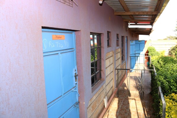 A building with a blue door labeled "Elephant" and a window with a metal gate.