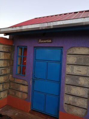 A building with a reception area, a blue door, and a sign that reads "Reception". - B & B Resort Marsabit (Marsabit)