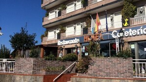 A hotel with a restaurant on the ground floor, multiple balconies, and a stone facade. - Hotel Internacional (O Porrino)