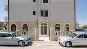 A two-story building with a central entrance, a balcony, and a gated driveway. - Spalato Dream Apartments (Split)