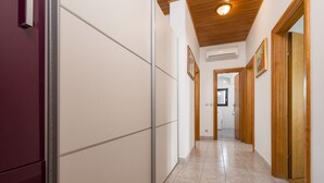 A hallway with a tiled floor, wooden doors, and a ceiling with a light fixture. - Spalato Dream Apartments (Split)