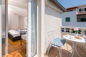 A balcony with a table, chair, and a small garden. - Spalato Dream Apartments (Split)