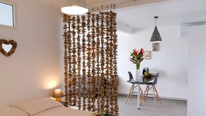 Hotelkamer met een bed, een bureau met stoel, een decoratieve houten wand en een hartvormige decoratie, plus een hanglamp.