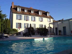 A large two-story building with a swimming pool in front.