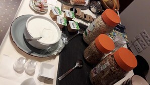 Una mesa de buffet con diversos alimentos, como pan, frutas y salsas.