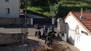 A hotel with a paved driveway, a gated entrance, and a sign indicating the hotel's name.