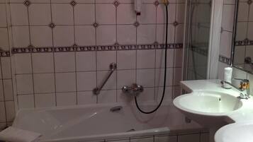 Een badkamer met een bad, een douche en een wastafel.