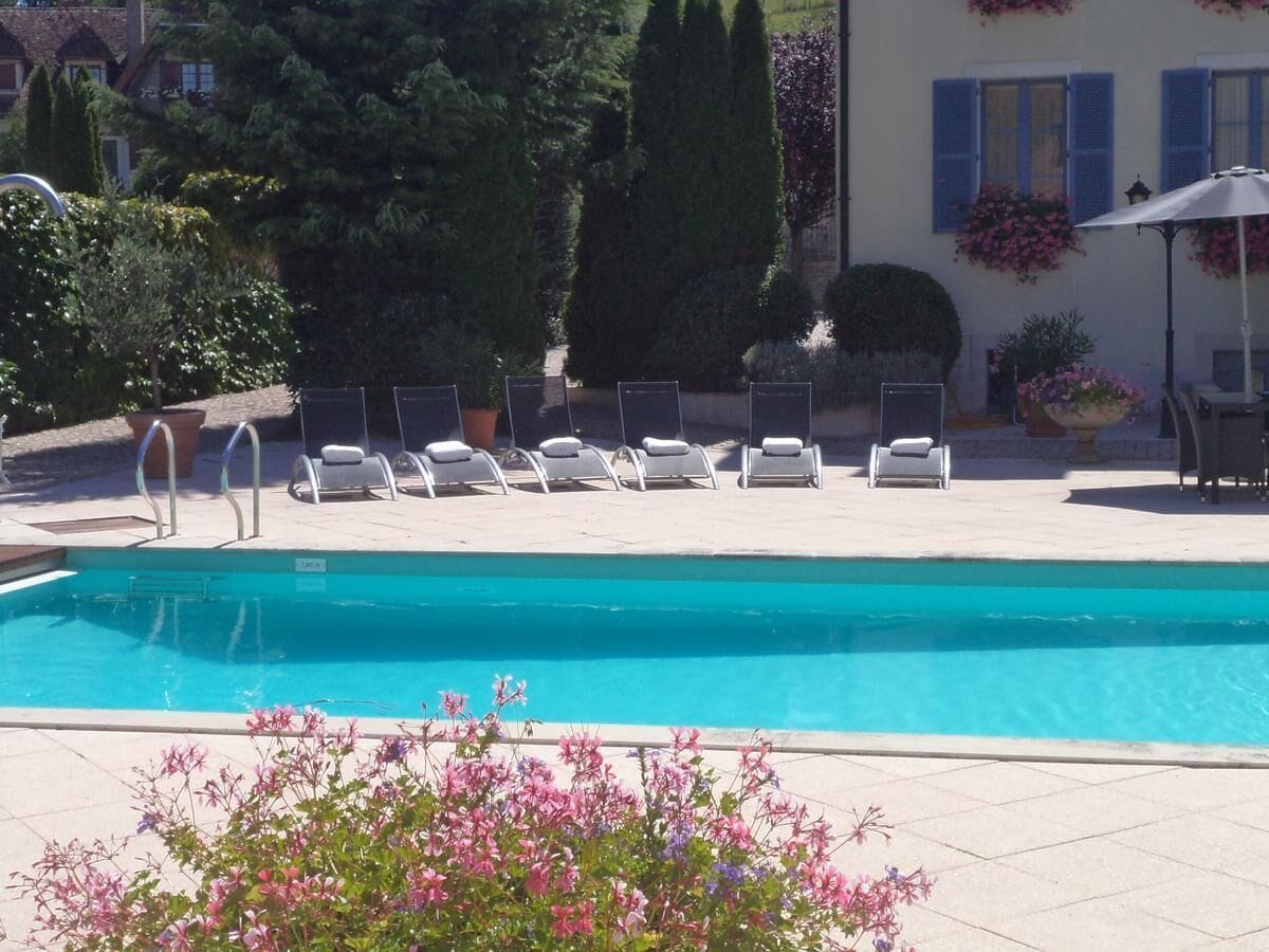 Una piscina con sillas de descanso y una sombrilla.