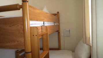 A bunk bed with a wooden frame and white bedding.
