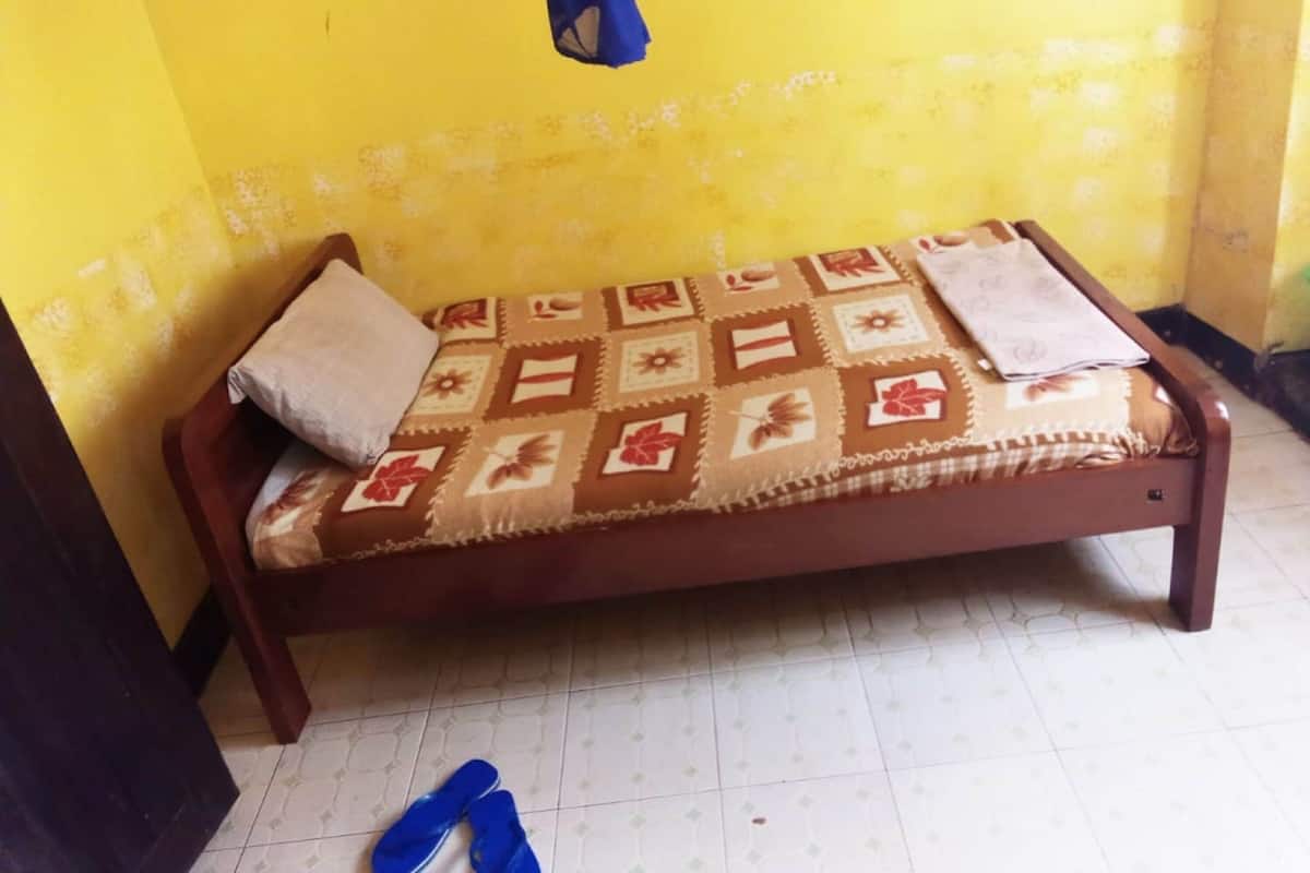 Uma cama de solteiro com um cobreleito estampado, um travesseiro e um edredom.
