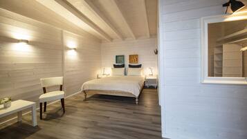 A bedroom with a bed, a chair, and a nightstand.