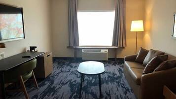 Een bureau, een laptopwerkplek, een strijkplank/strijkijzer, beddengoed