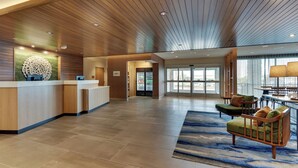 A spacious lobby with a wooden ceiling, a reception desk, and seating area with a blue patterned rug. - Fairfield Inn & Suites by Marriott Warsaw (Warsaw)