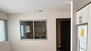 A modern kitchen with a central island, a dining area with a sofa, and a view into the adjacent living space. - Suite location and comfort in Quito Hi speed wifi (Quito)