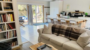 A living room with a sofa, a coffee table, and a bookshelf. - Walking distance to East Hampton village  (East Hampton)