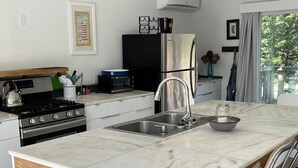 A modern kitchen with a central island, stainless steel appliances, and a view of the outdoors. - Walking distance to East Hampton village  (East Hampton)