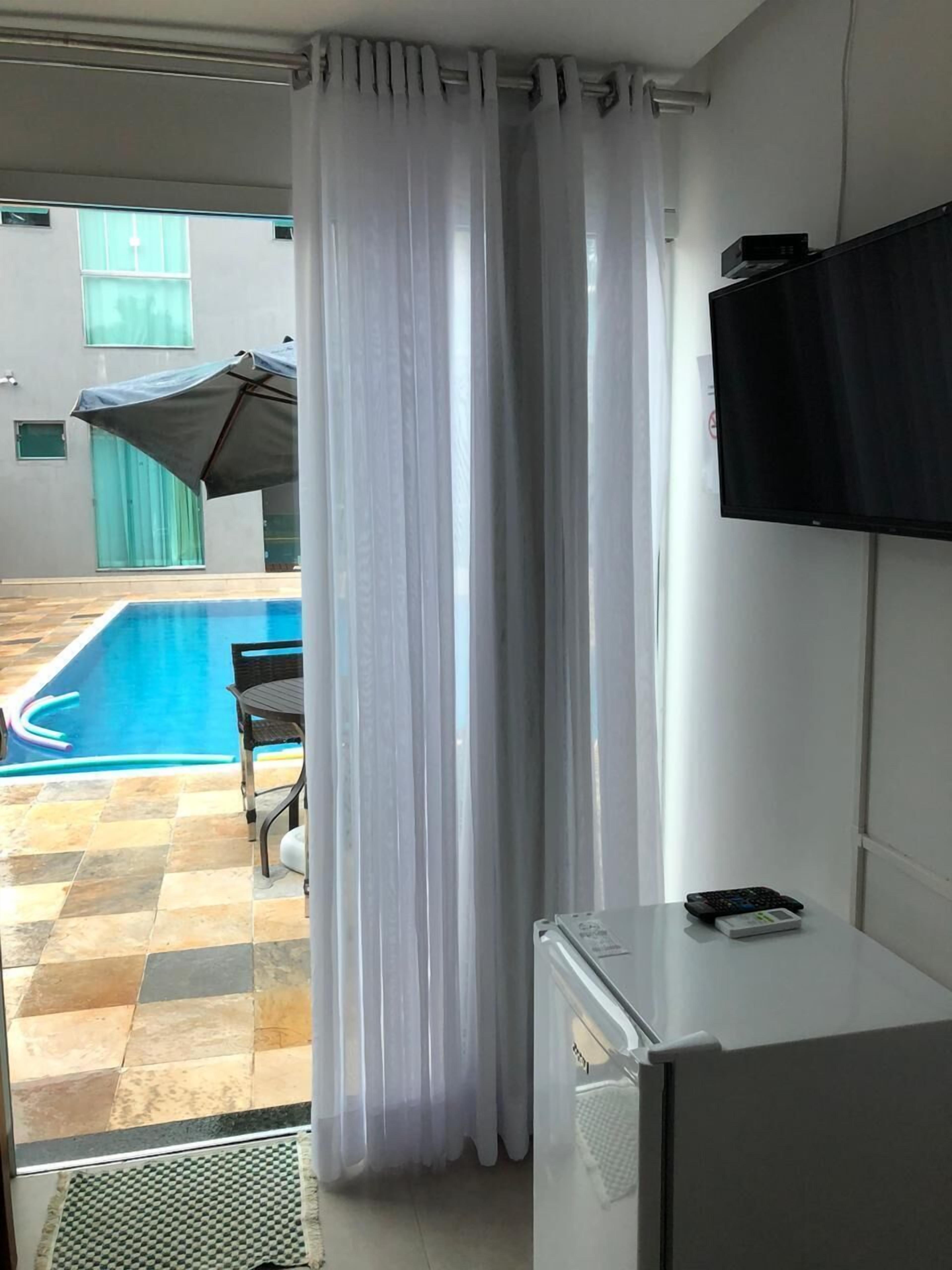 A room with a pool, a TV, and a refrigerator.