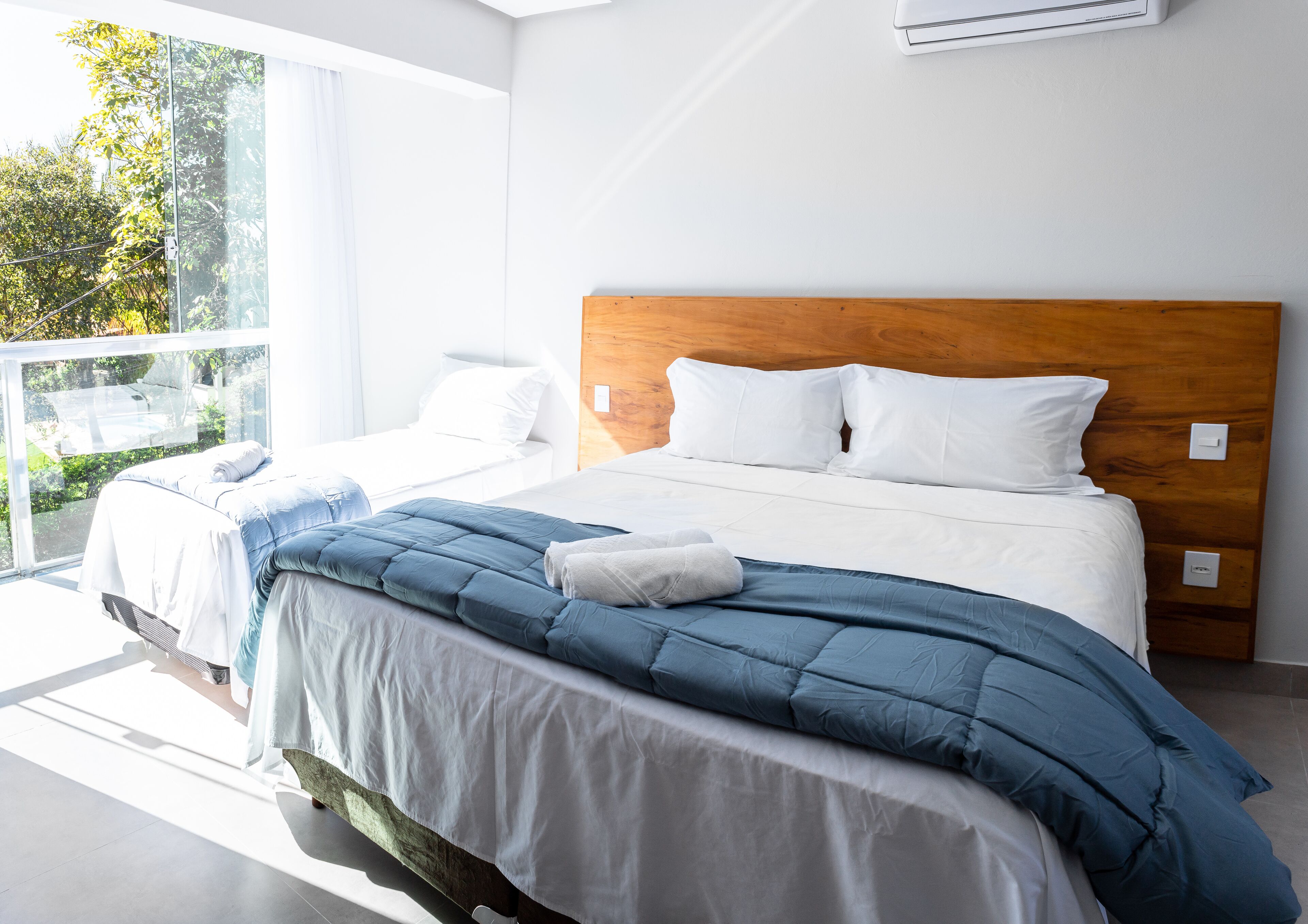 A modern bedroom with a large bed, white bedding, and a wooden headboard.